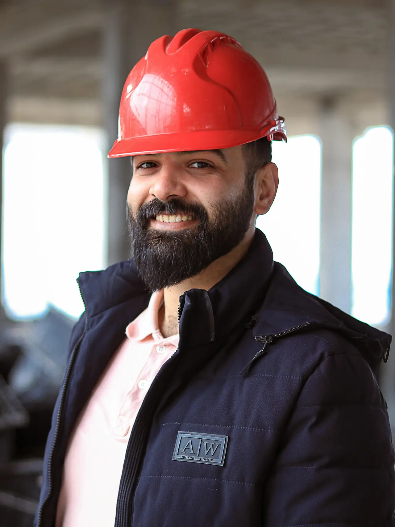 Construction superintendent in a red hard hat on a concrete jobsite