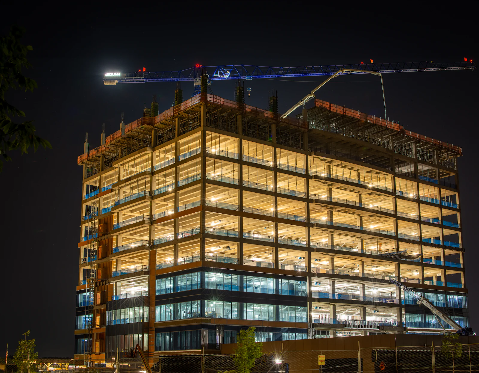 Commercial office building under construction lit up at night
